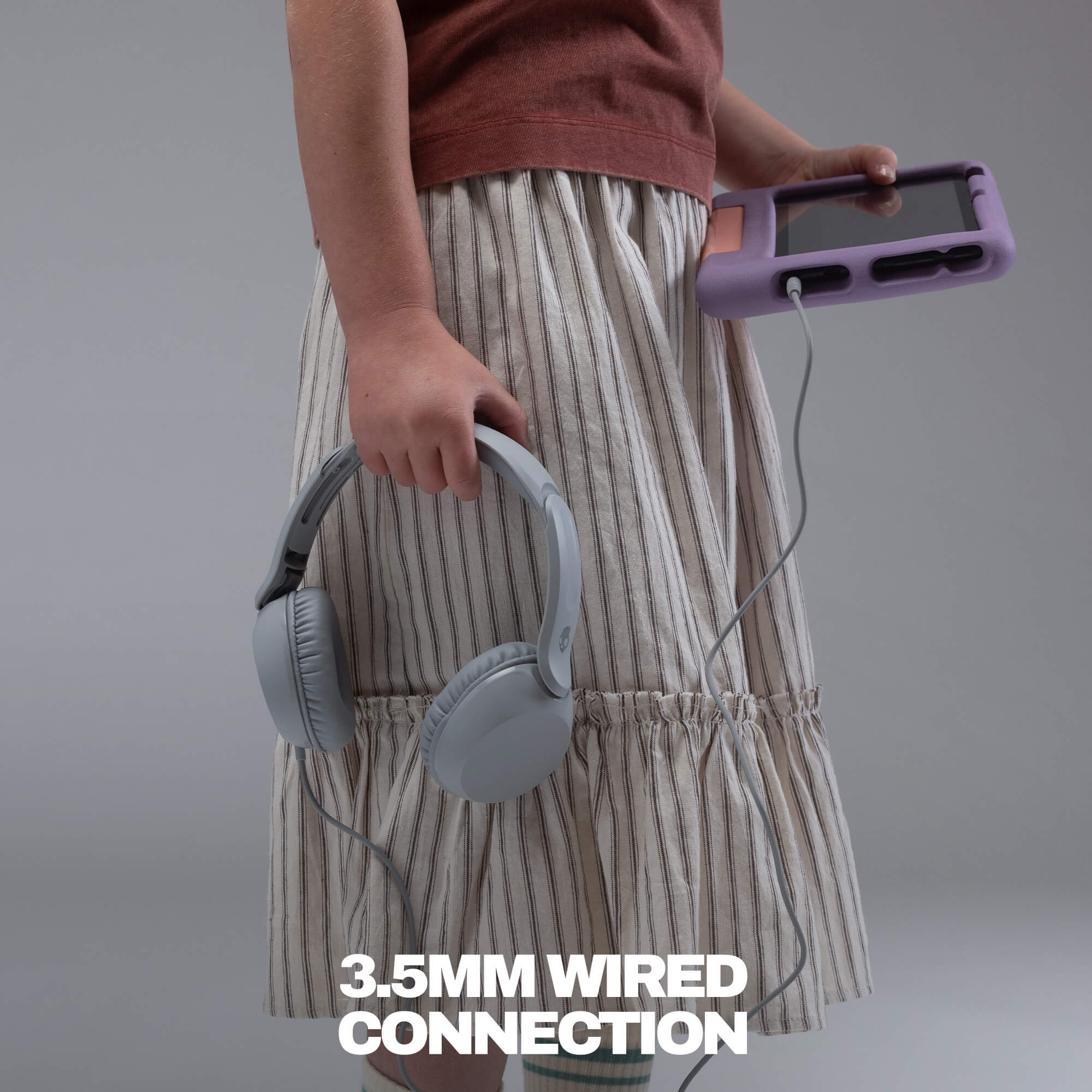 A person wearing a beige and white striped skirt holds a pair of light gray over-ear headphones and a purple portable music player connected by a 3.5mm wired cable, with white text at the bottom reading '3. | Cement