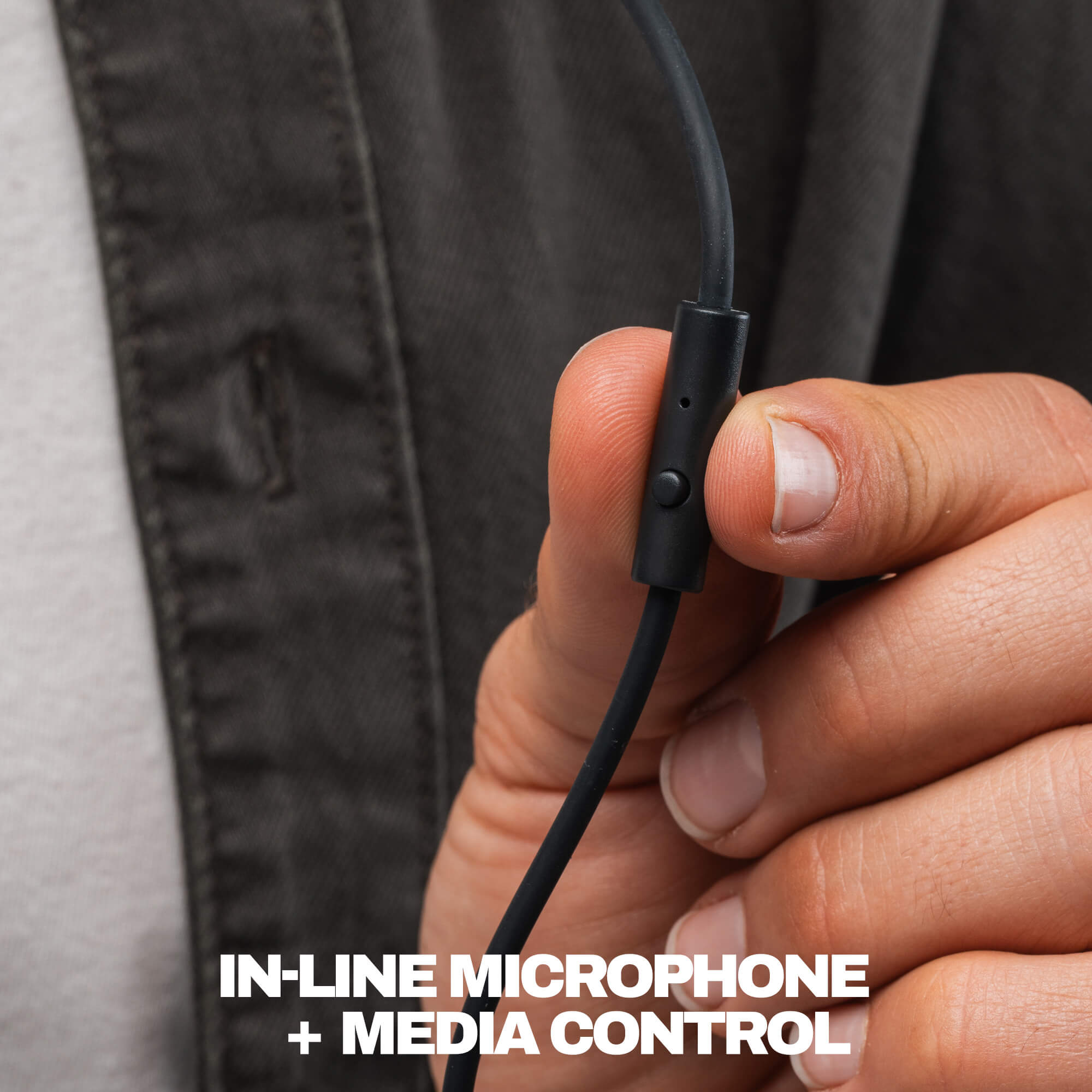 Close-up of a person's hand holding a black wired in-line microphone and media control module, with white text at the bottom reading 'IN-LINE MICROPHONE + MEDIA CONTROL'. | True Black