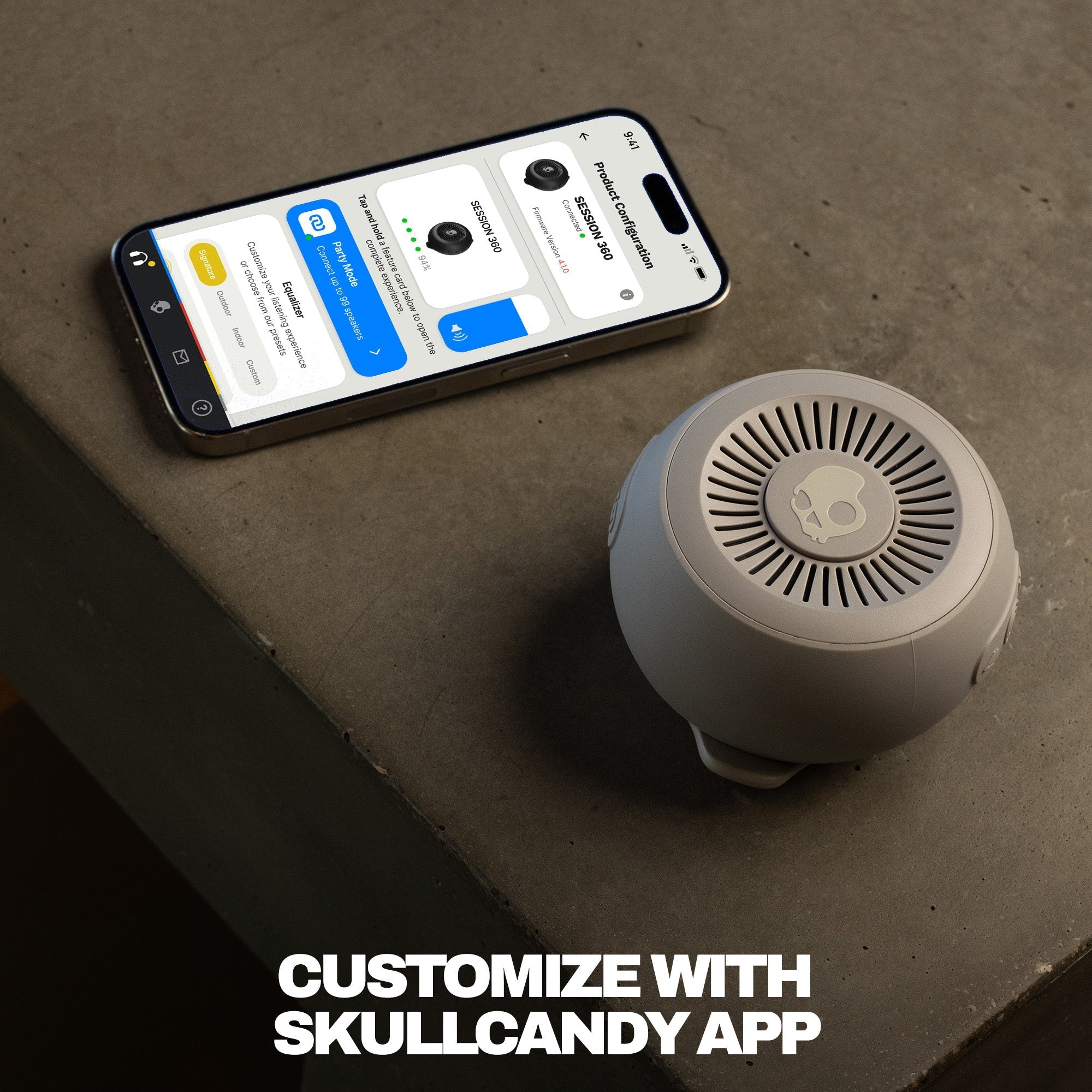 Smartphone displaying an app interface next to a cylindrical device on a concrete surface with text 'Customize with Skullcandy App'. | Cement
