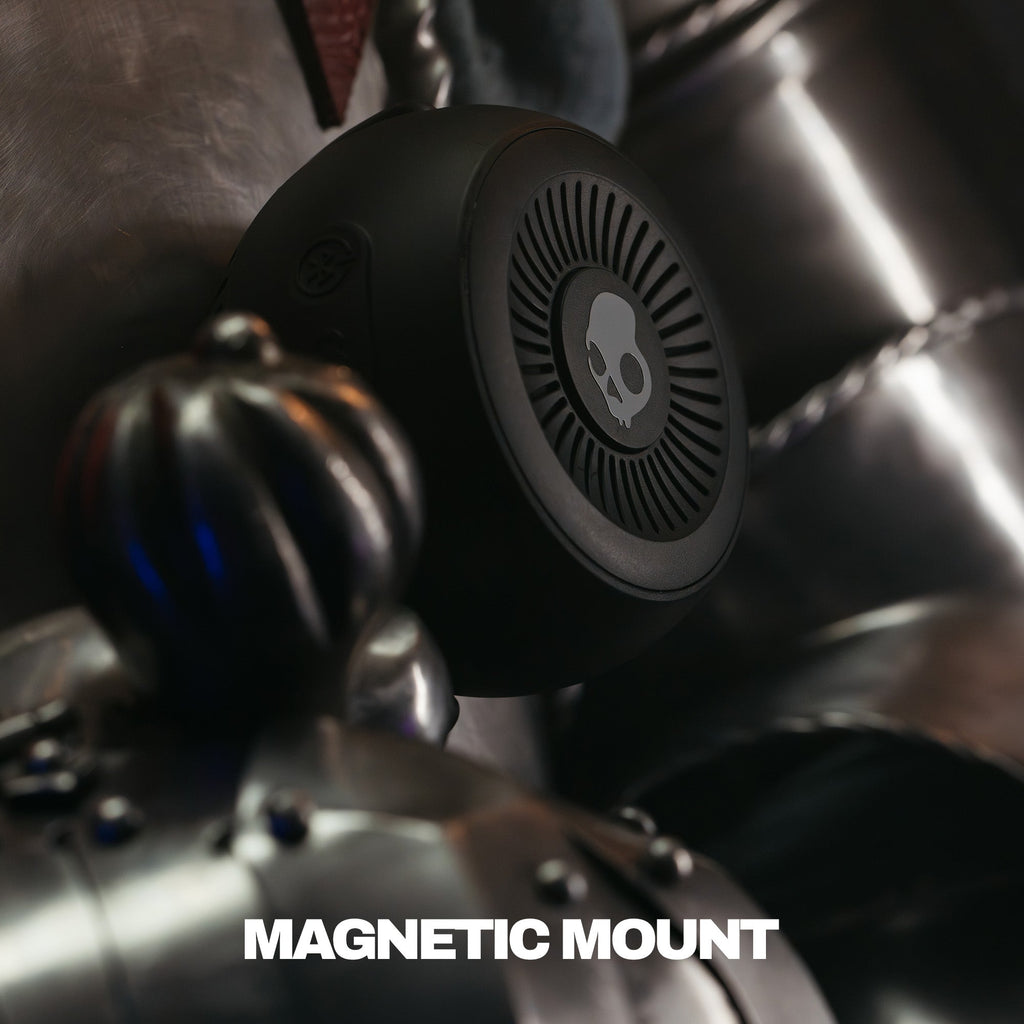 Close-up of a speaker with a magnetic mount attached, featuring a brand logo. | True Black