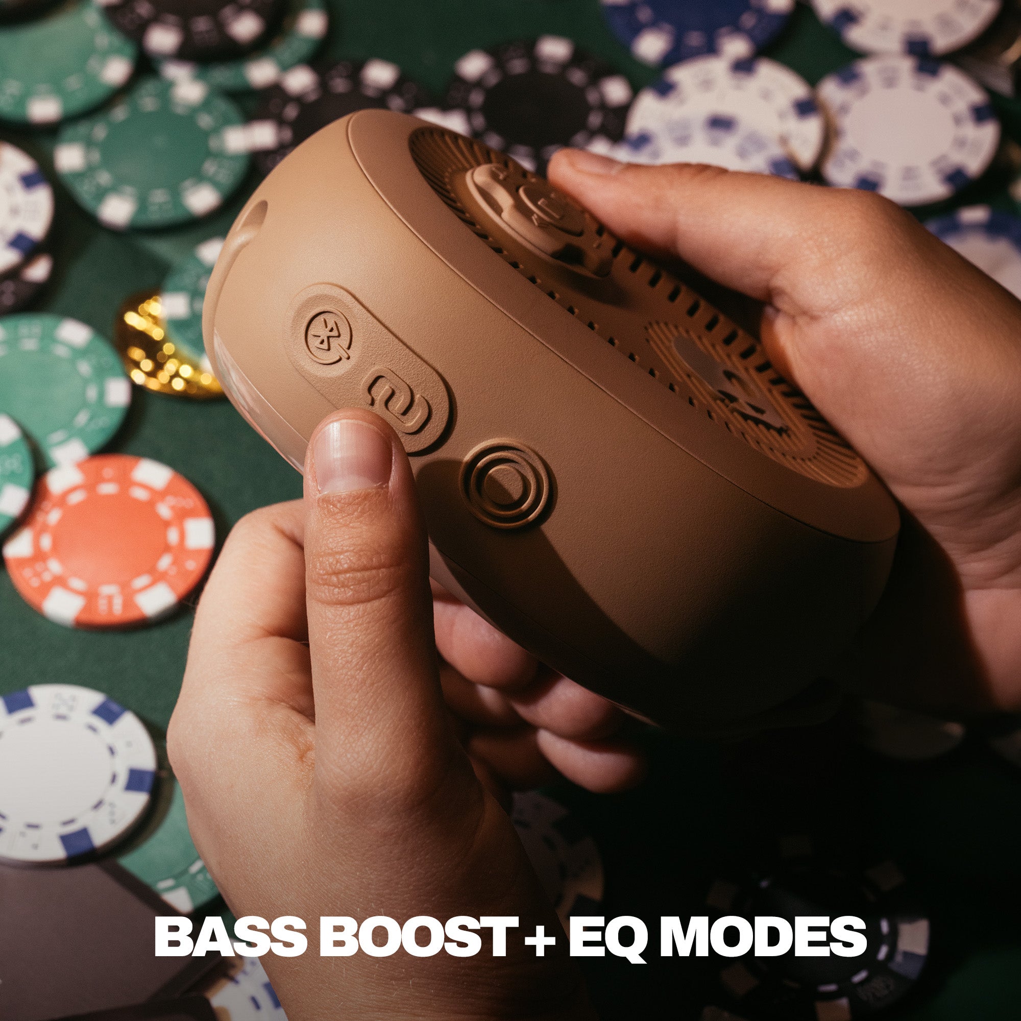 Hand holding a brown audio device with poker chips in the background | Primer