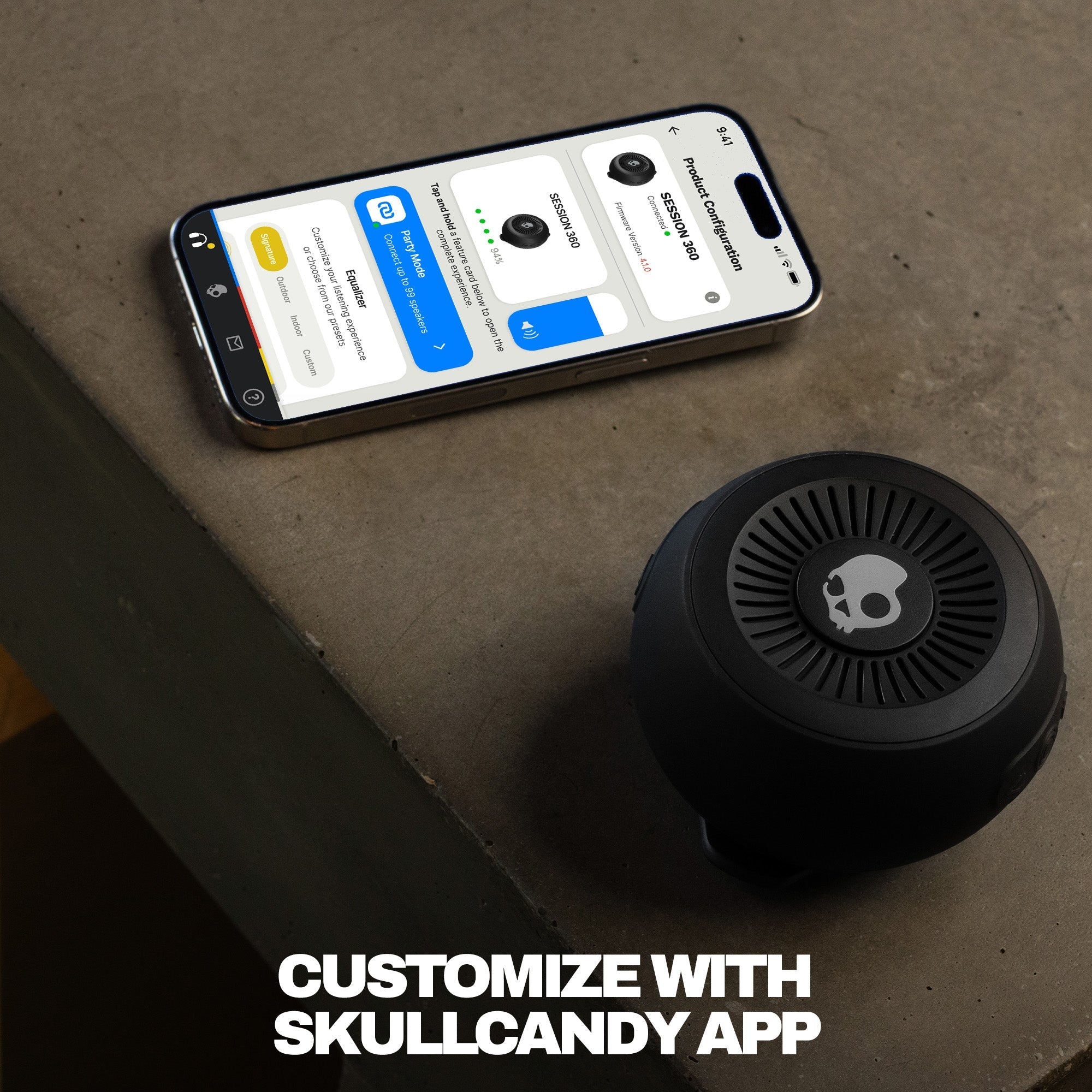 Black skull-shaped speaker next to a smartphone displaying an app interface on a concrete surface. | True Black