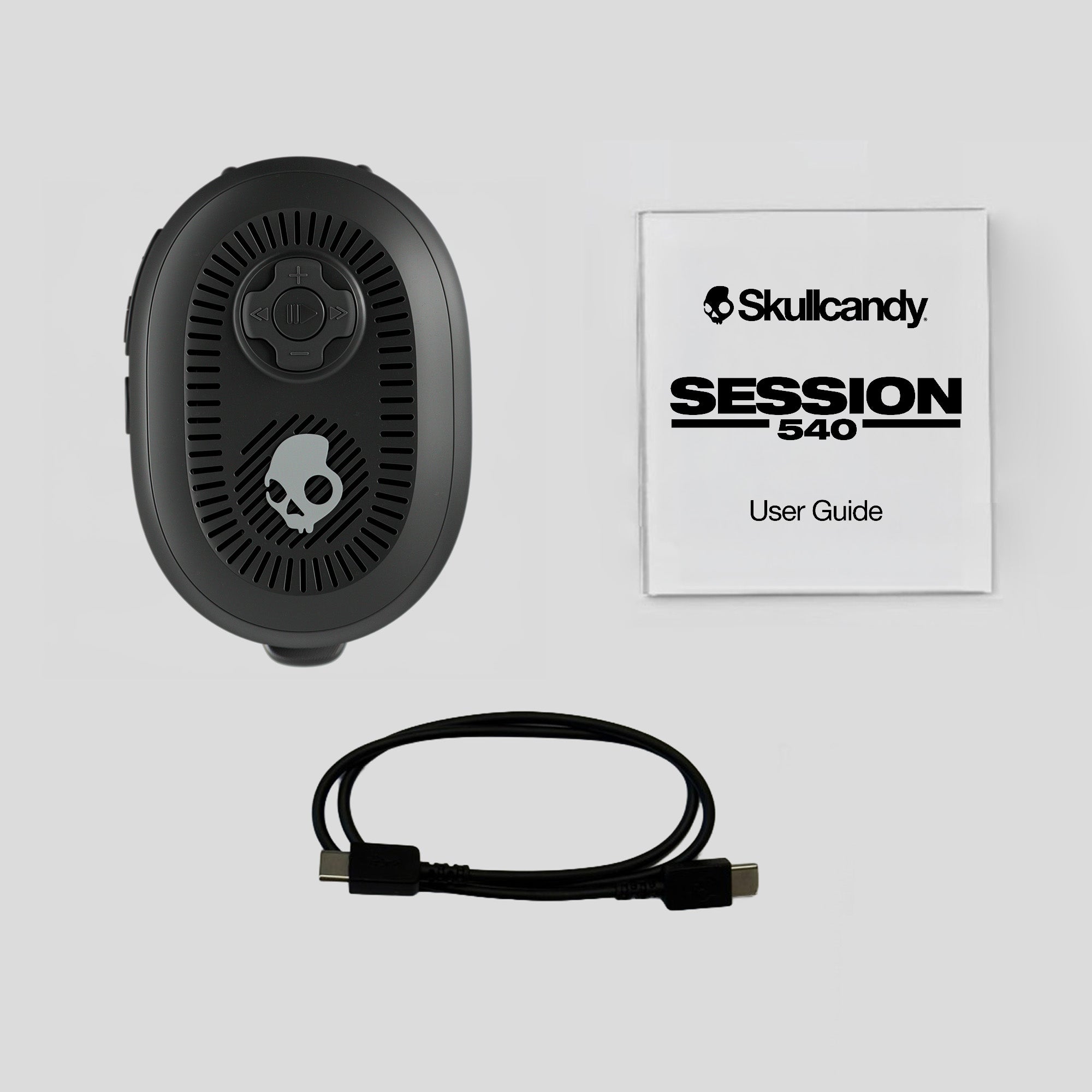 Black electronic device with cable and Skullcandy user guide on a light gray background | Primer