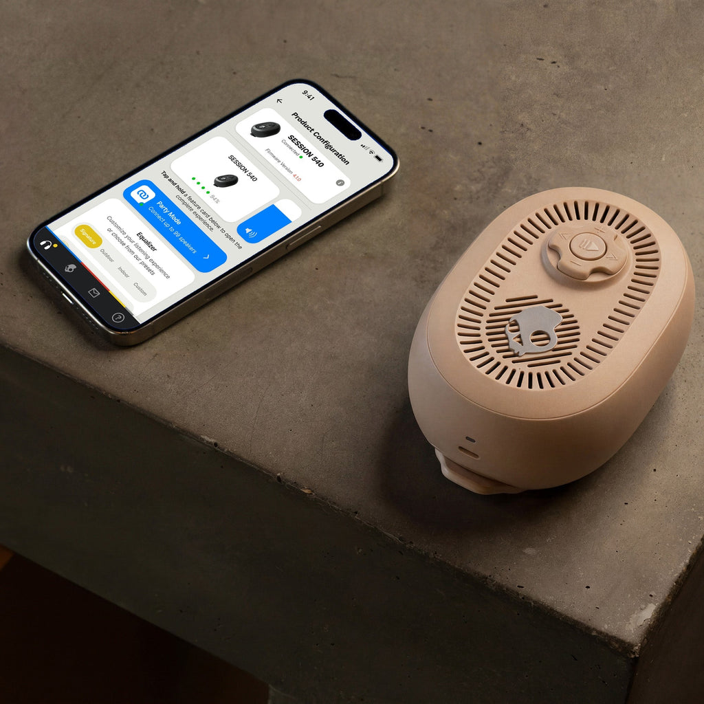 Smart device with app interface next to a cylindrical beige device on a concrete surface | Primer